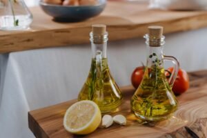 Fresh garlic and lemon with olive oil bottles, perfect for Italian cuisine. Captures freshness and flavor.